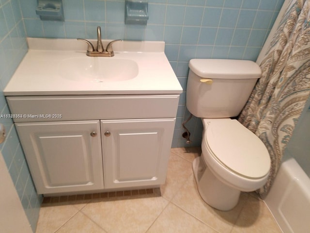 full bathroom with tile patterned floors, vanity, tile walls, and toilet