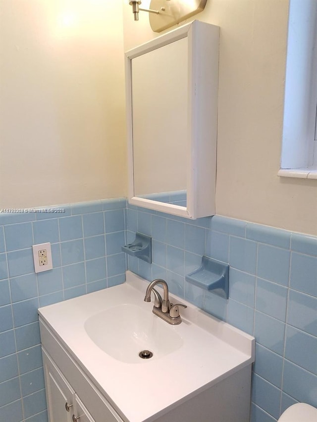 bathroom with vanity and tile walls