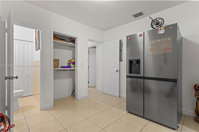 kitchen featuring light tile patterned floors and stainless steel refrigerator with ice dispenser