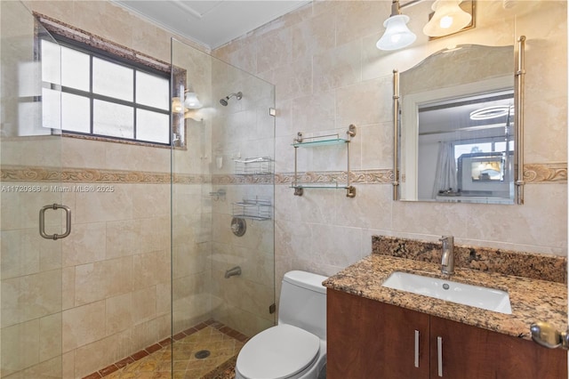 bathroom featuring walk in shower, vanity, toilet, and tile walls