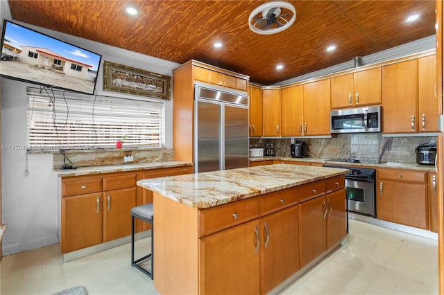 kitchen with a center island, wooden ceiling, stainless steel appliances, backsplash, and a breakfast bar