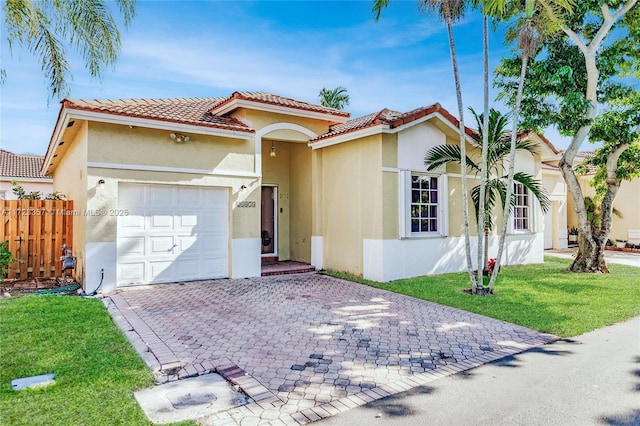 mediterranean / spanish-style home with a garage and a front lawn