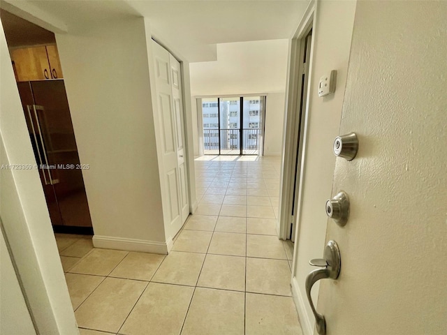 hallway featuring expansive windows and light tile patterned flooring