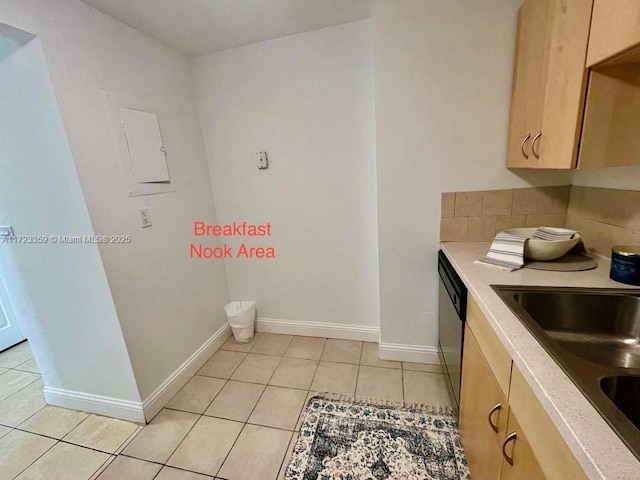 kitchen featuring dishwasher, light brown cabinets, light tile patterned flooring, and sink