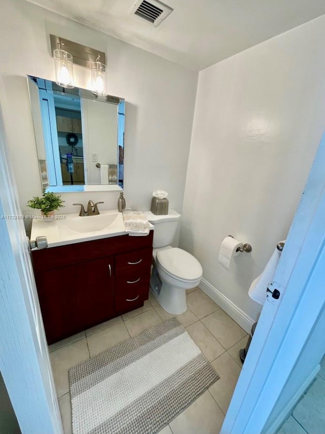 bathroom featuring tile patterned floors, vanity, and toilet