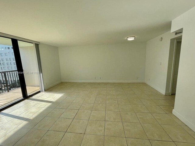 tiled spare room with expansive windows