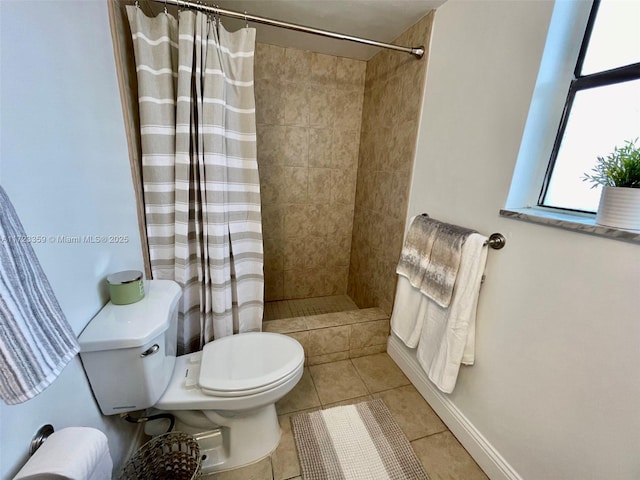 bathroom featuring tile patterned flooring, toilet, and walk in shower