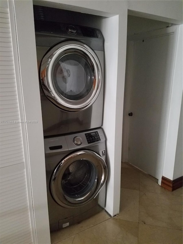 clothes washing area featuring stacked washer / dryer and light tile patterned floors