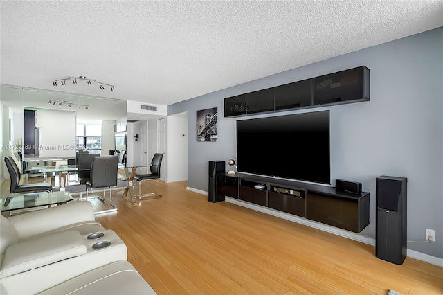 living room with wood-type flooring and a textured ceiling