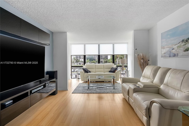 living room featuring light hardwood / wood-style flooring, expansive windows, and a textured ceiling