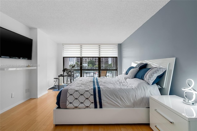 bedroom with a textured ceiling and light wood-type flooring