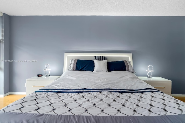 bedroom featuring a textured ceiling and light hardwood / wood-style floors