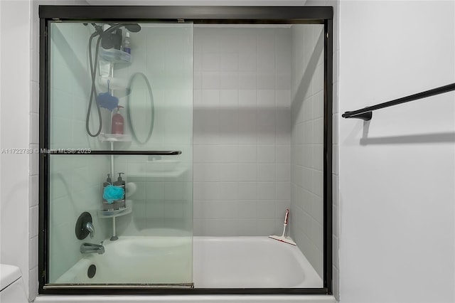 bathroom featuring toilet and enclosed tub / shower combo