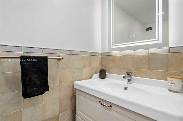 bathroom with vanity and tile walls