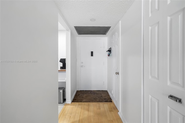 hallway featuring a textured ceiling and hardwood / wood-style flooring