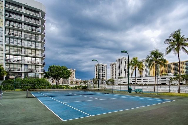 view of tennis court featuring basketball hoop