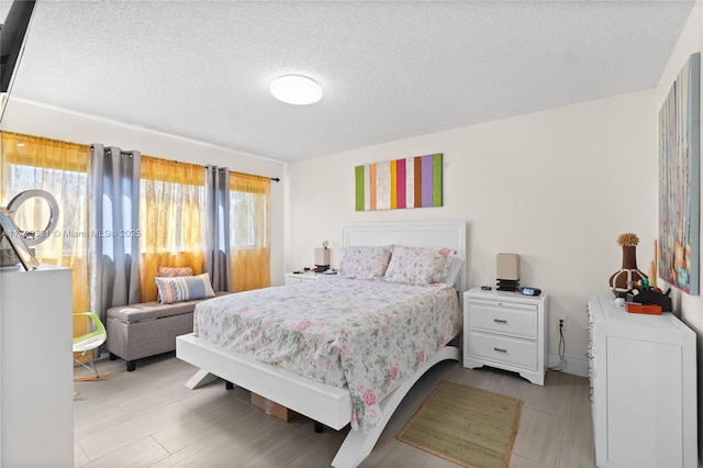 bedroom with light hardwood / wood-style floors and a textured ceiling