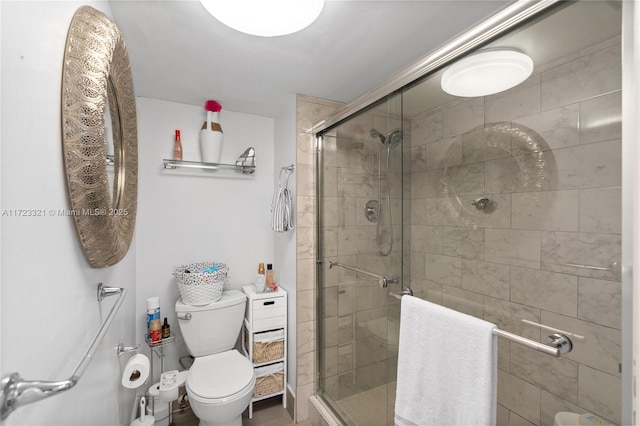 bathroom featuring toilet and a shower with door