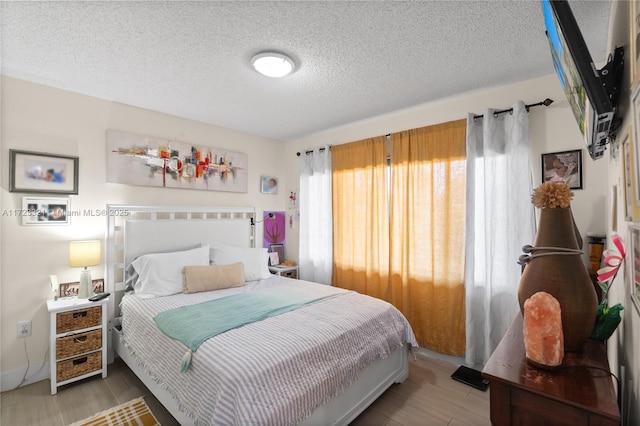 bedroom featuring wood-type flooring and a textured ceiling