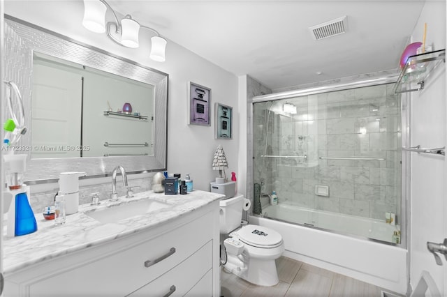 full bathroom with vanity, enclosed tub / shower combo, and toilet