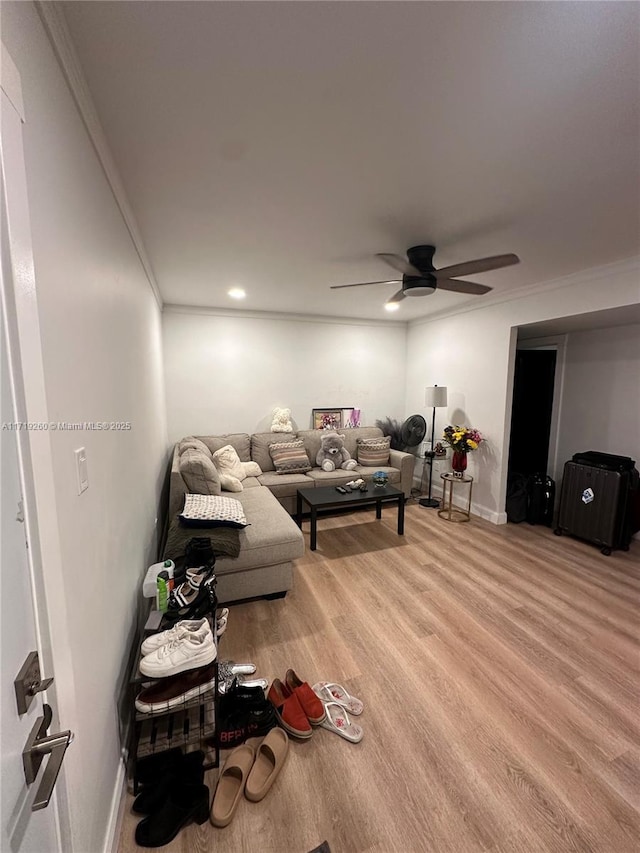 living room featuring hardwood / wood-style flooring, ceiling fan, and crown molding