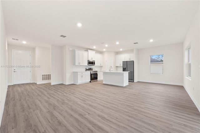 unfurnished living room featuring light hardwood / wood-style flooring and sink