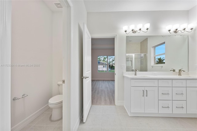 bathroom with tile patterned floors, vanity, an enclosed shower, and toilet