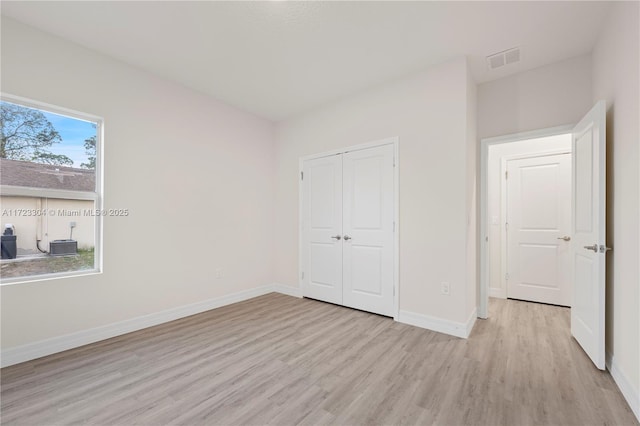 unfurnished bedroom featuring a closet and light hardwood / wood-style flooring