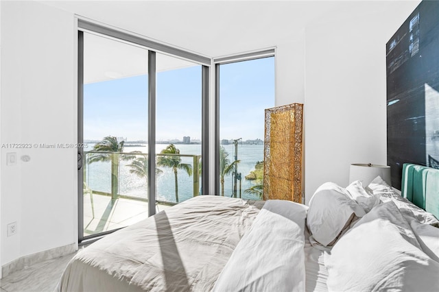 bedroom with a water view, a wall of windows, and access to outside