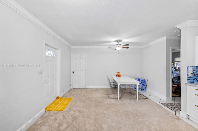 dining room featuring crown molding, ceiling fan, and light carpet