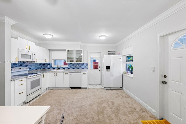 kitchen featuring tasteful backsplash, crown molding, light colored carpet, white appliances, and white cabinets