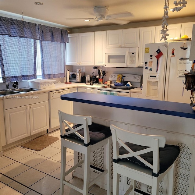 kitchen with sink, hanging light fixtures, light tile patterned floors, white appliances, and white cabinets