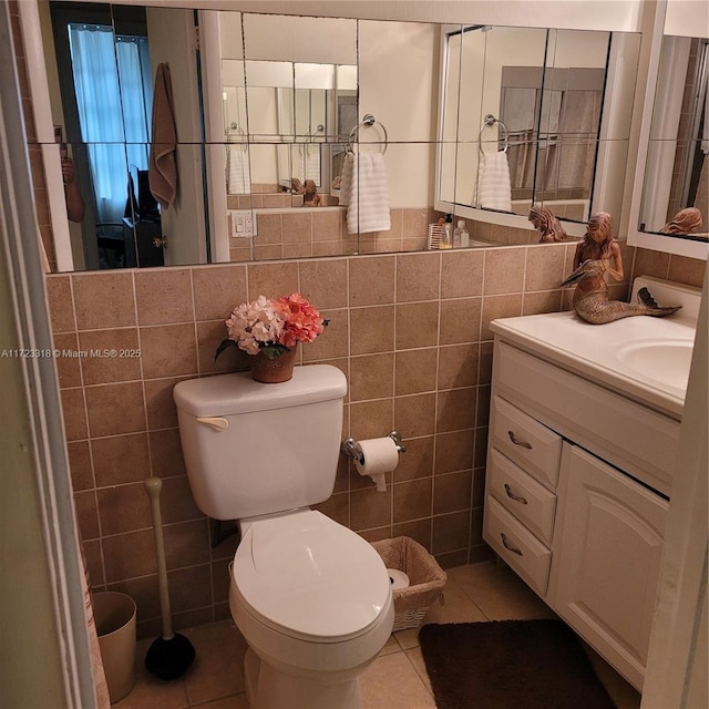 bathroom with tile patterned floors, vanity, toilet, and tile walls