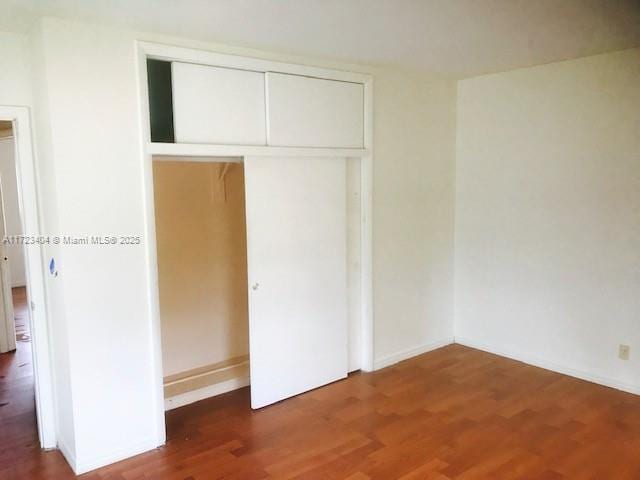 unfurnished bedroom with hardwood / wood-style floors and a closet