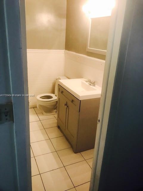 bathroom featuring tile patterned floors, vanity, and toilet