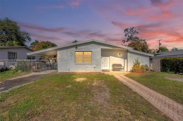 rear view of house featuring a carport and a yard