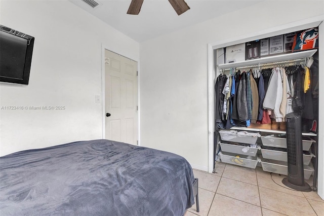 tiled bedroom with ceiling fan and a closet