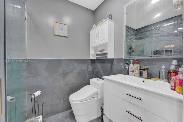 bathroom featuring toilet, vanity, tile walls, backsplash, and a shower with door