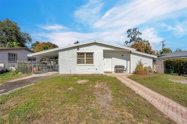 back of property with a lawn and a carport