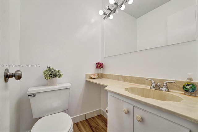 bathroom featuring wood-type flooring, vanity, and toilet