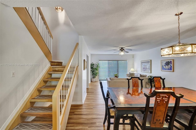 dining room featuring ceiling fan, wood-type flooring, and a textured ceiling