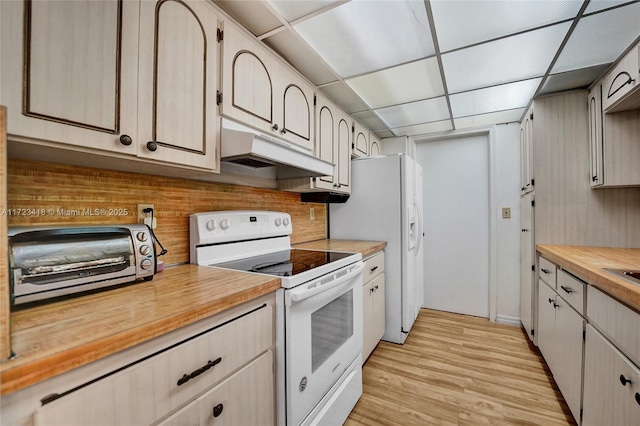 kitchen featuring a drop ceiling, light hardwood / wood-style floors, white appliances, and wood counters