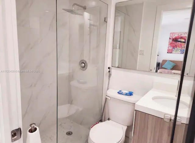 bathroom featuring tiled shower, vanity, and toilet