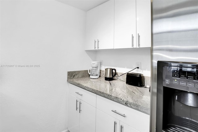 kitchen featuring white cabinetry, light stone countertops, and stainless steel fridge with ice dispenser