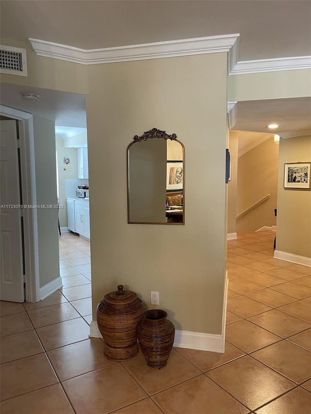 hallway featuring tile patterned floors and crown molding