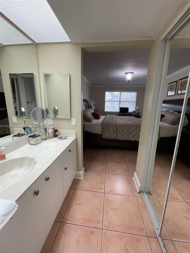 bathroom featuring tile patterned flooring, vanity, and ornamental molding