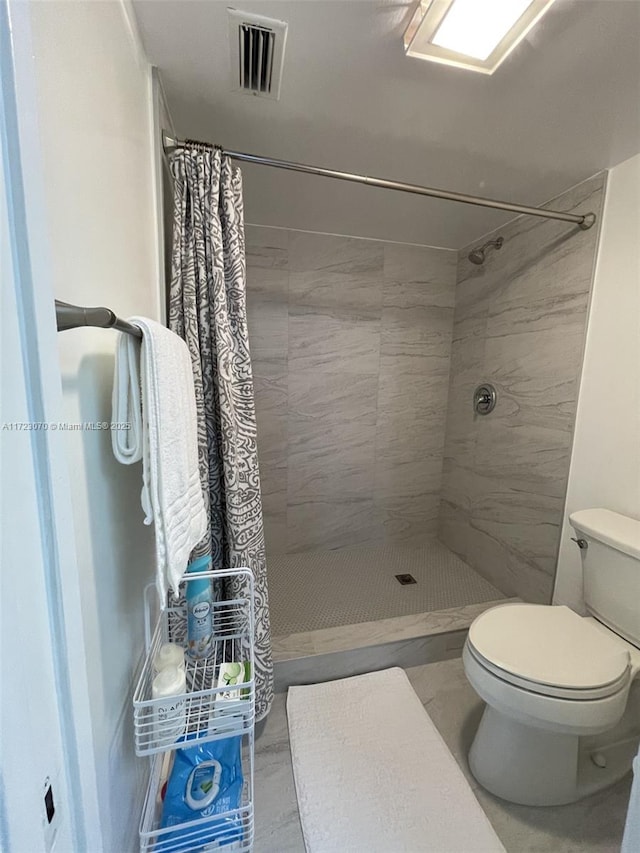 bathroom featuring a shower with curtain and toilet