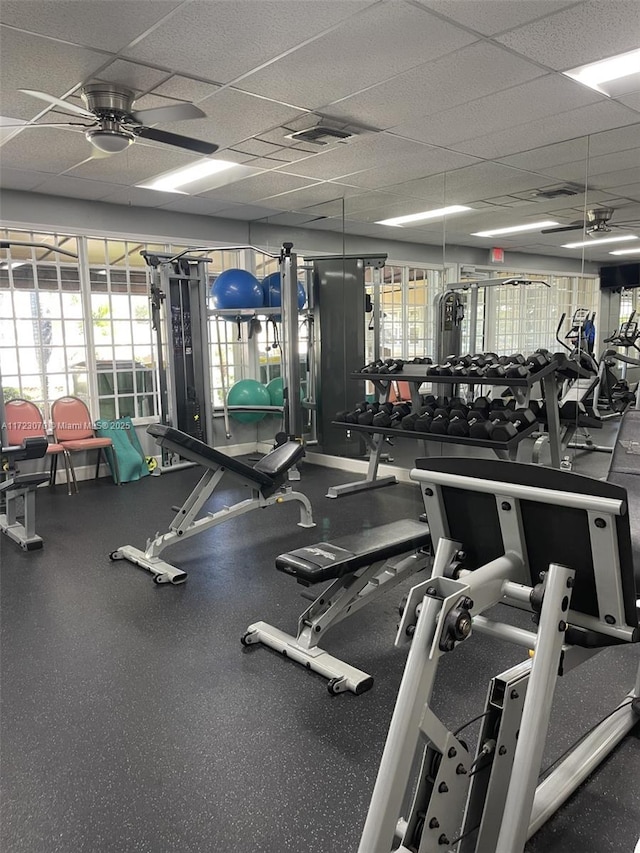 gym with ceiling fan and a drop ceiling