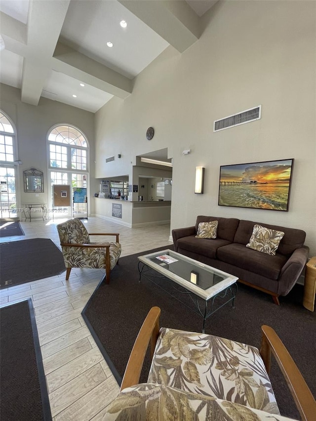 living room with beamed ceiling and a towering ceiling