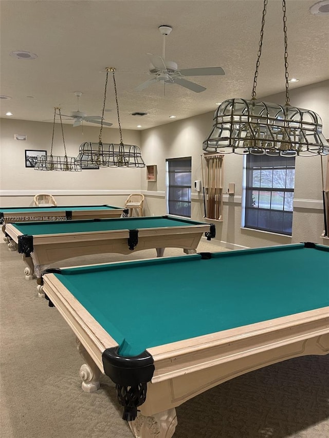 recreation room featuring carpet flooring, ceiling fan, and a textured ceiling